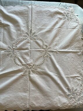 vintage white linen tablecloth featuring intricate hand-crochet lace cutouts and